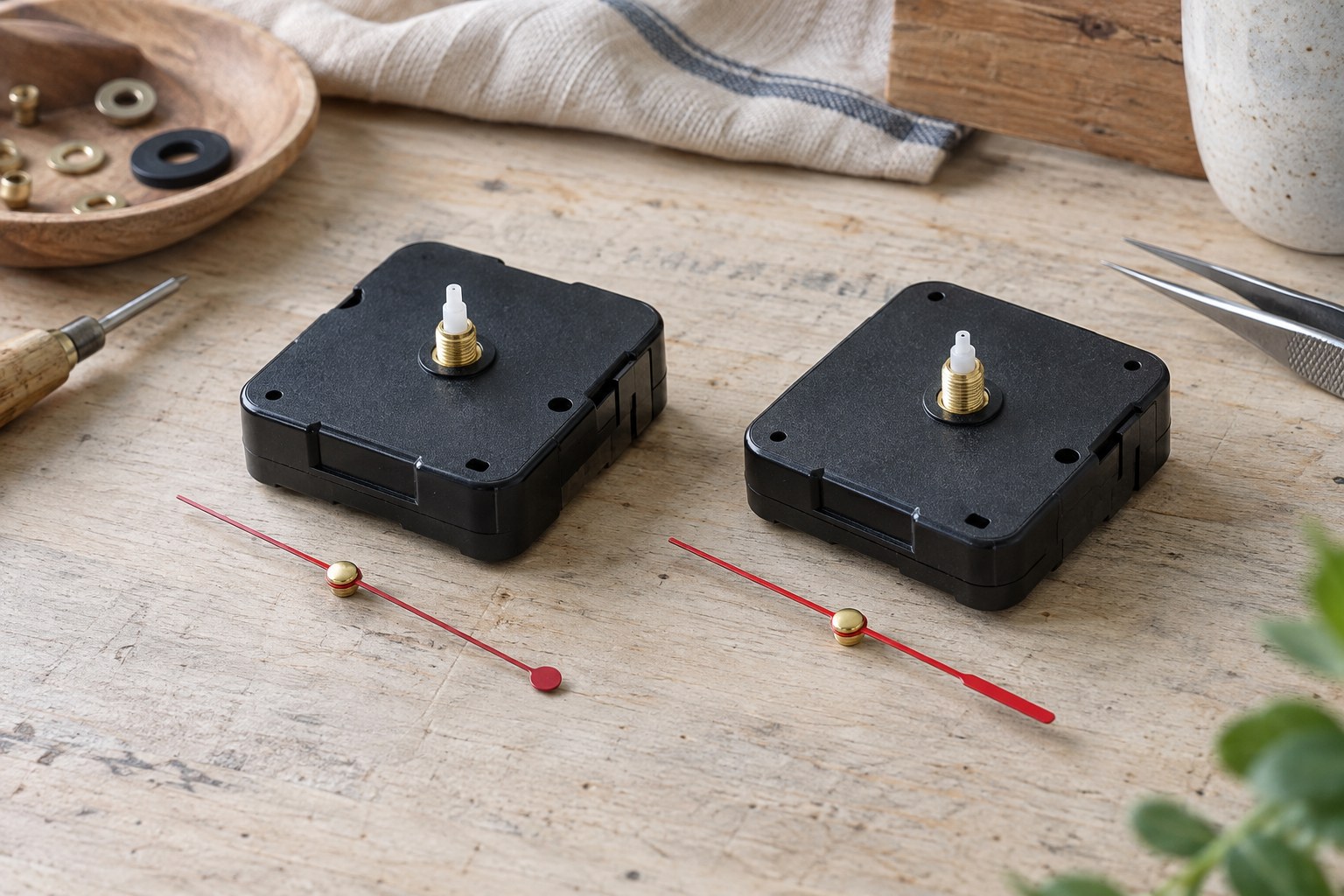 Two compact quartz clock movements with separate red second hands on a workbench