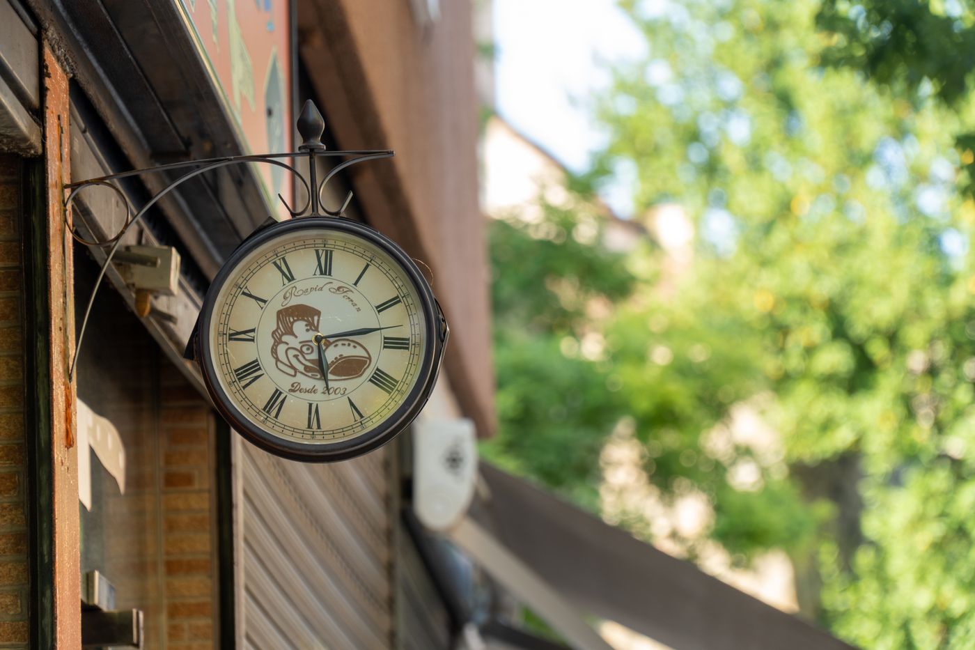 An exterior wall clock sheltered under the building edge