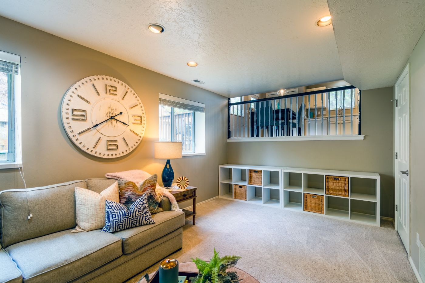 A large clock above a sofa showing its scale within a room