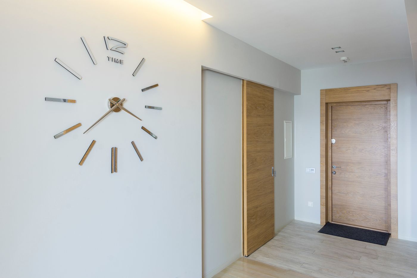 An open clock face with separate markers in a hallway