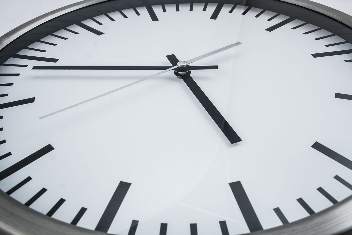 Angled view of the space between clock hands and the glass cover