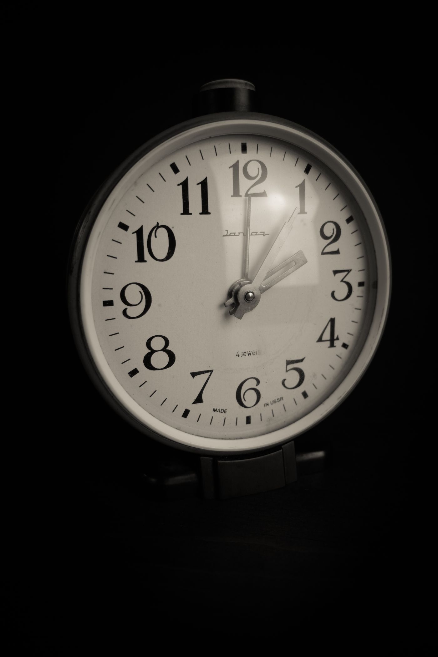 A pale clock face with strongly contrasting black hands and numbers