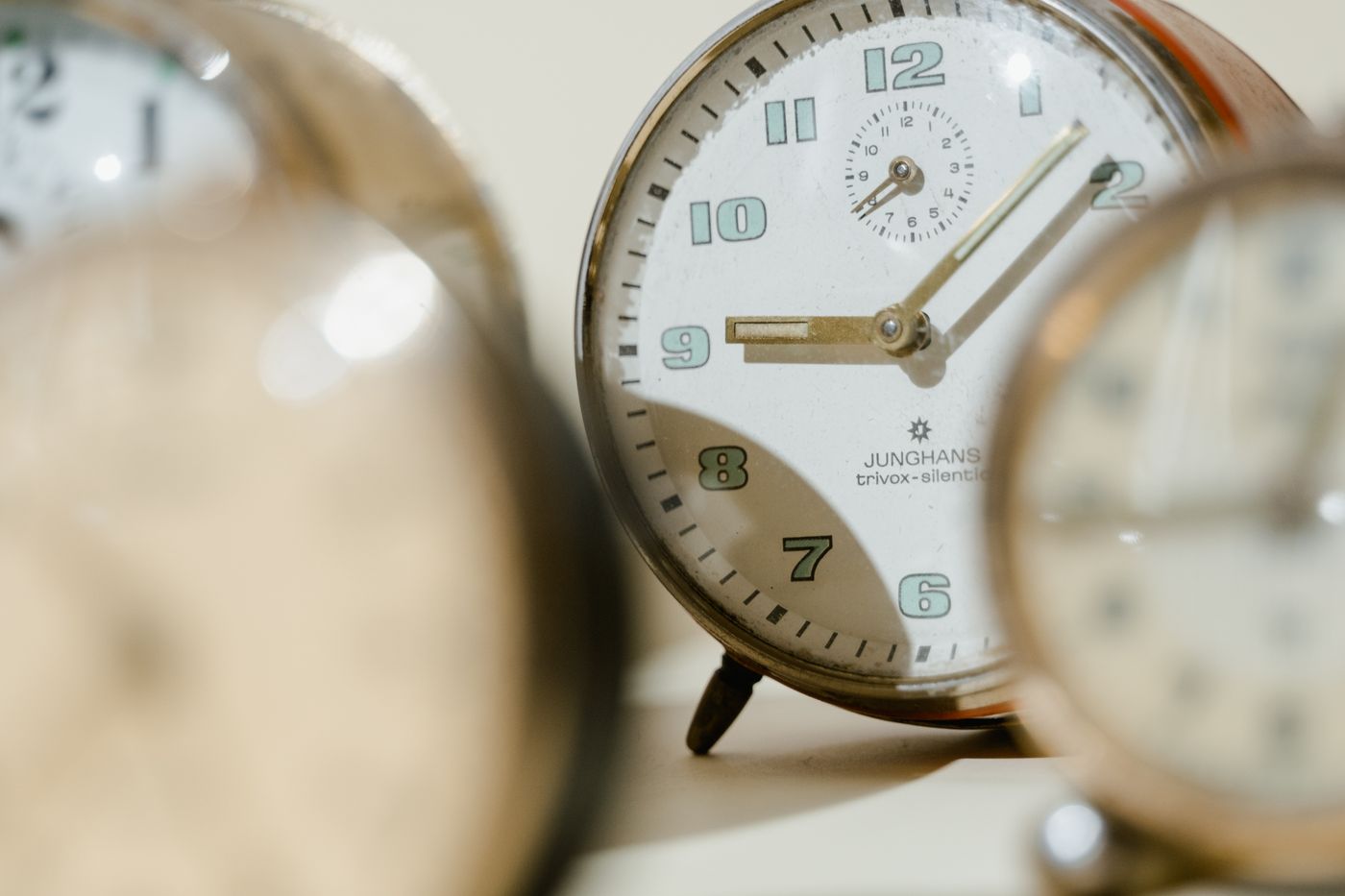 A close view of an older alarm clock face and case