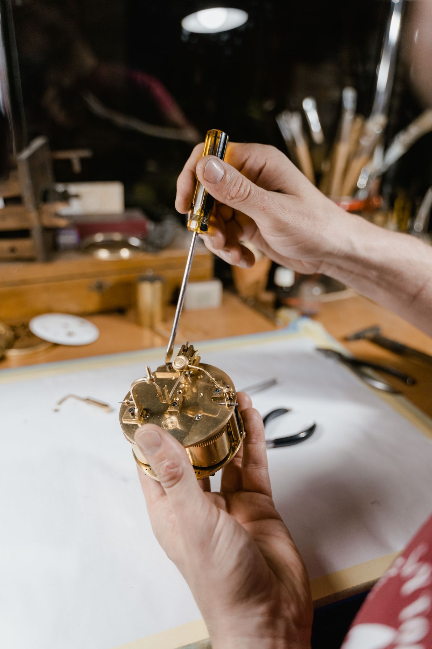 A repairer examining the movement of a mechanical clock