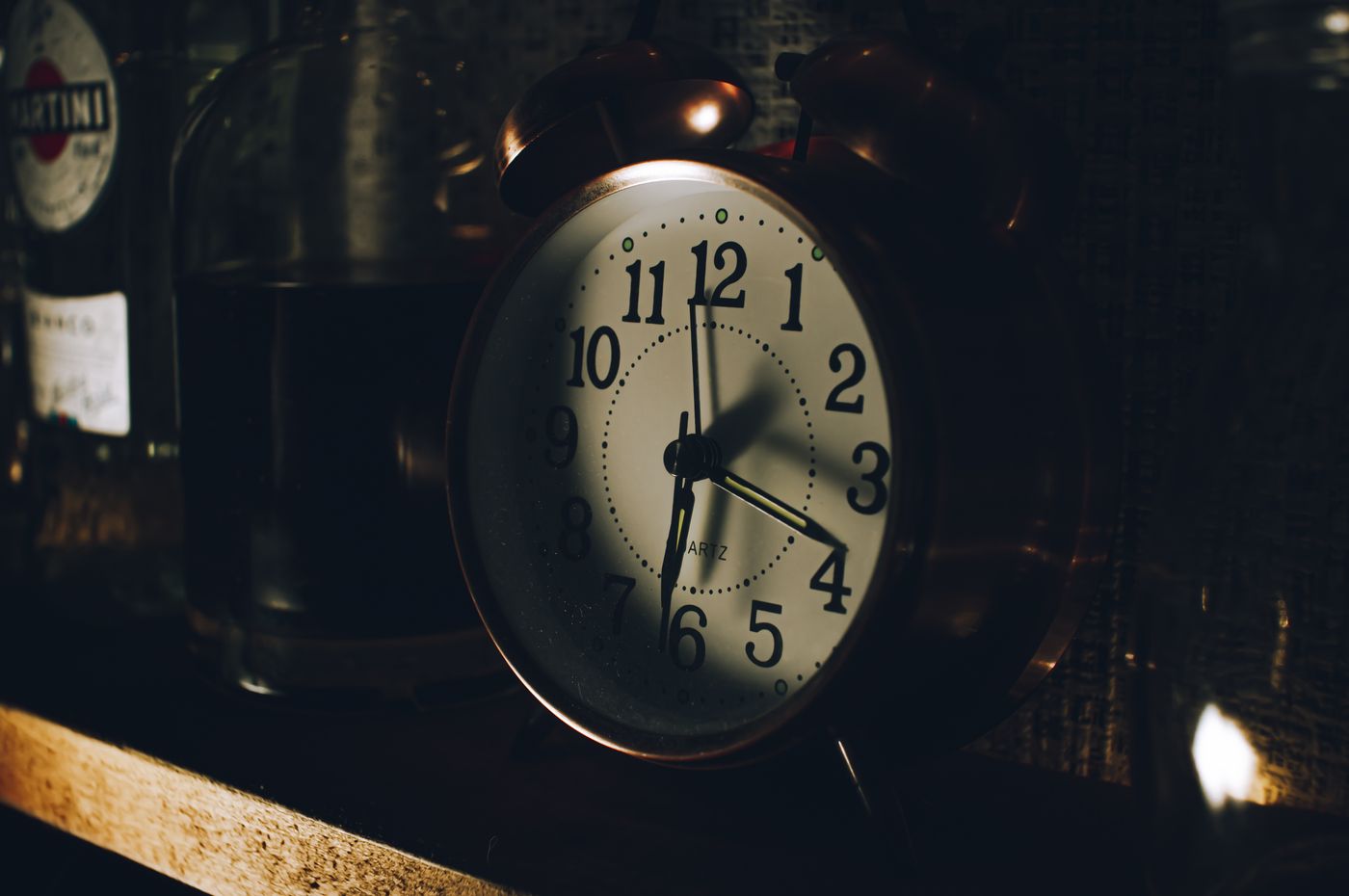 A vintage alarm clock displayed among older shelf objects