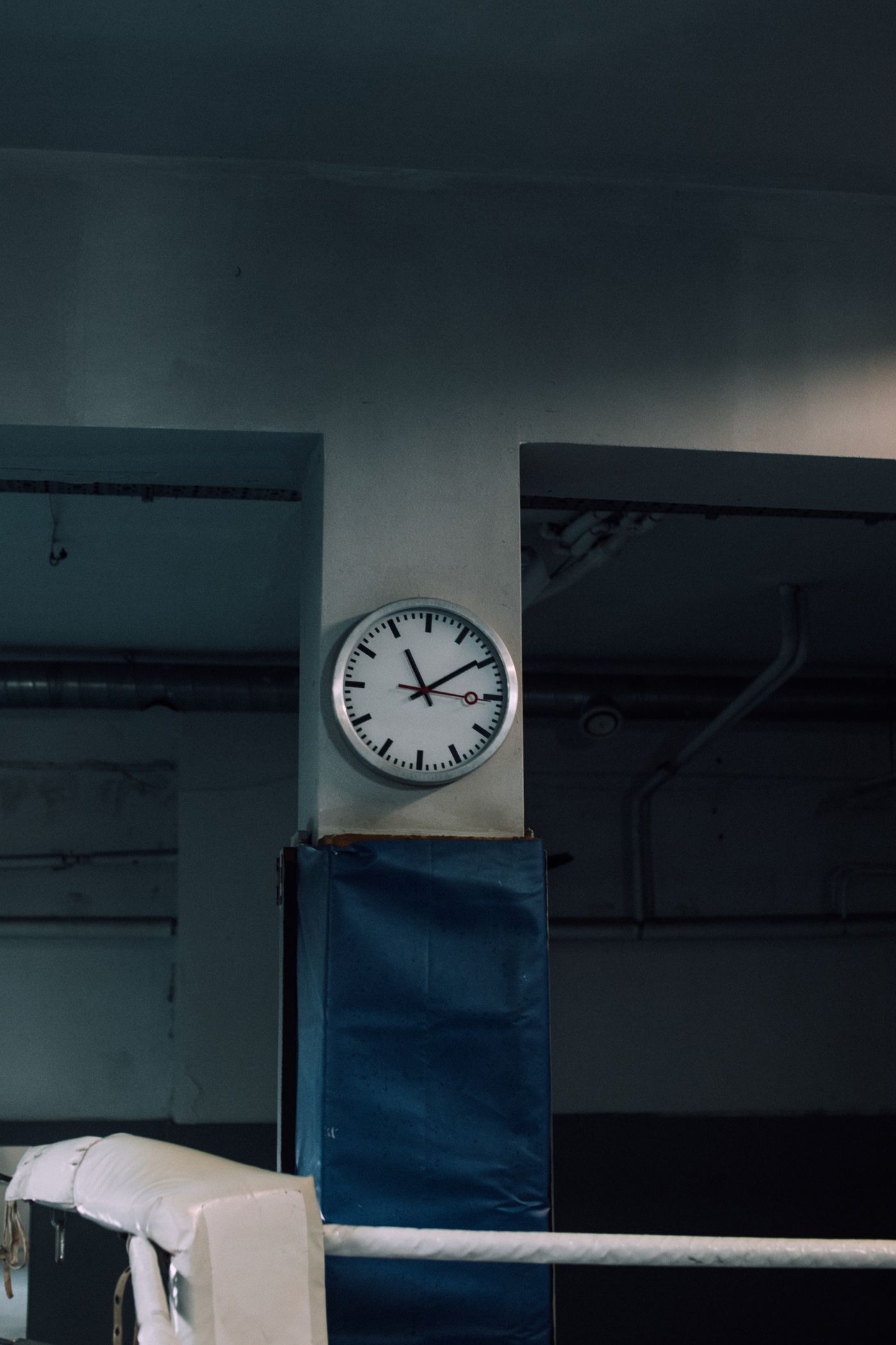A simple school-style numbered clock mounted in a large room