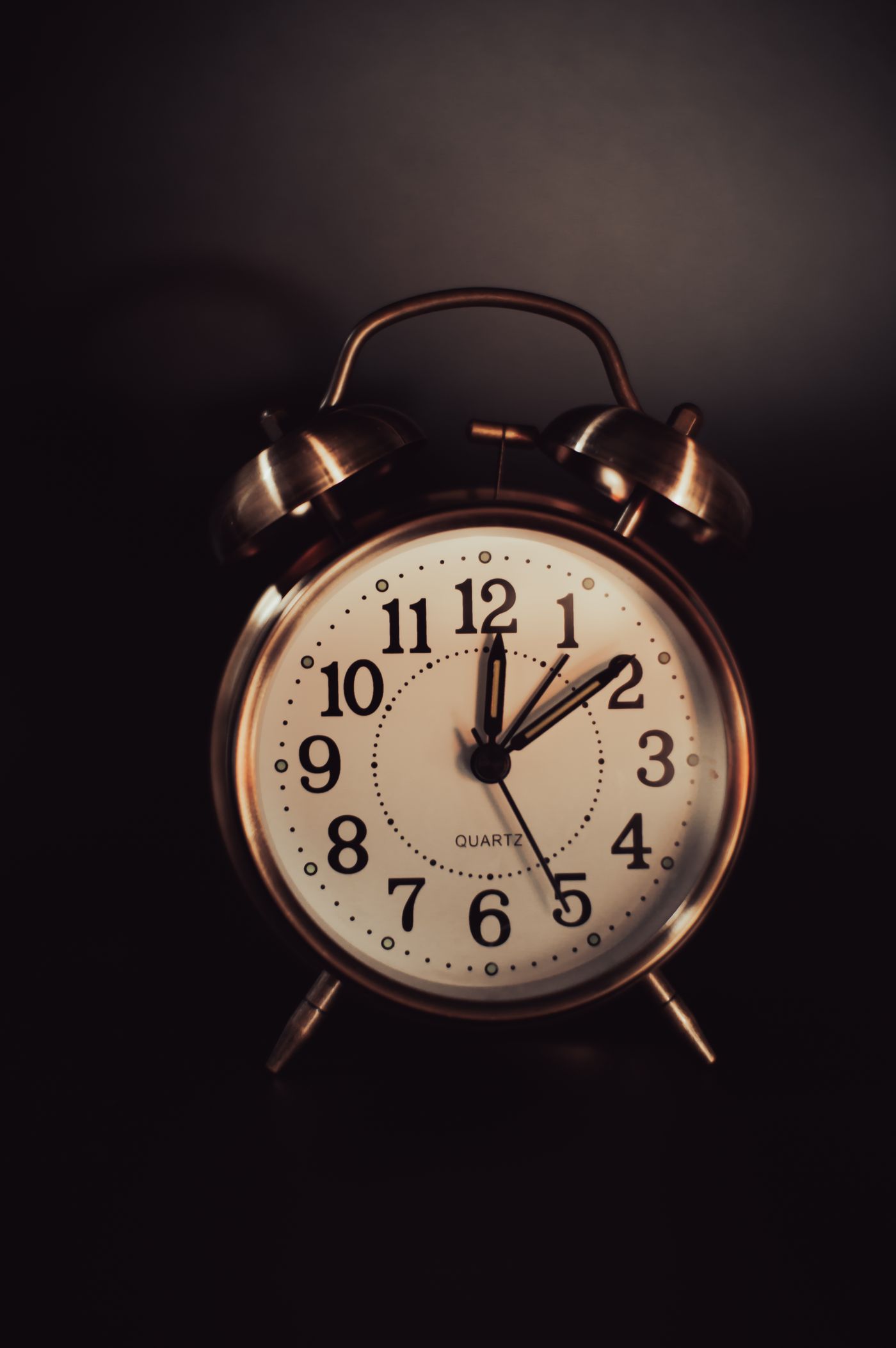 A vintage metal alarm clock with a cream numbered dial