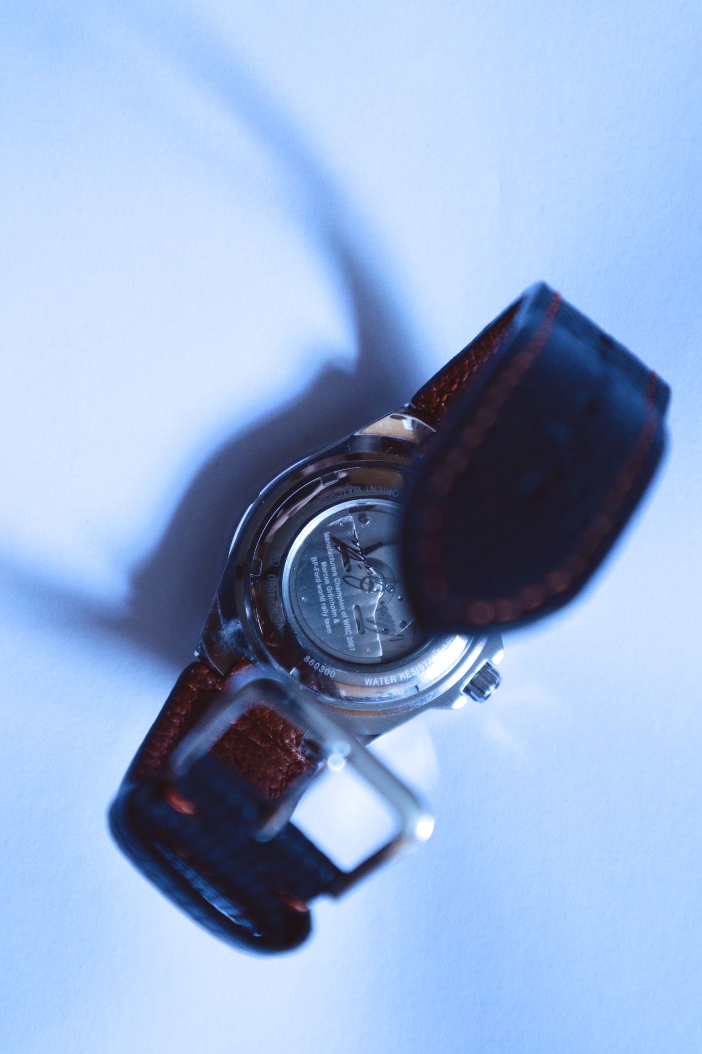 The back of a wristwatch with leather strap ends attached at its lugs