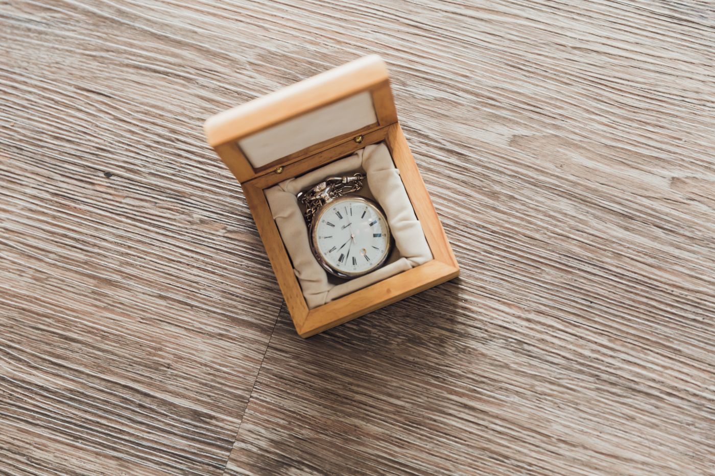 A wristwatch held on a cushion inside a wooden storage box