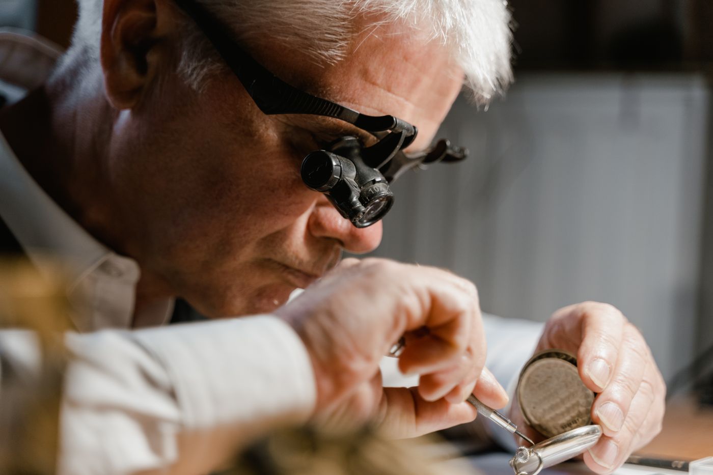 A watch repairer working carefully on a timepiece